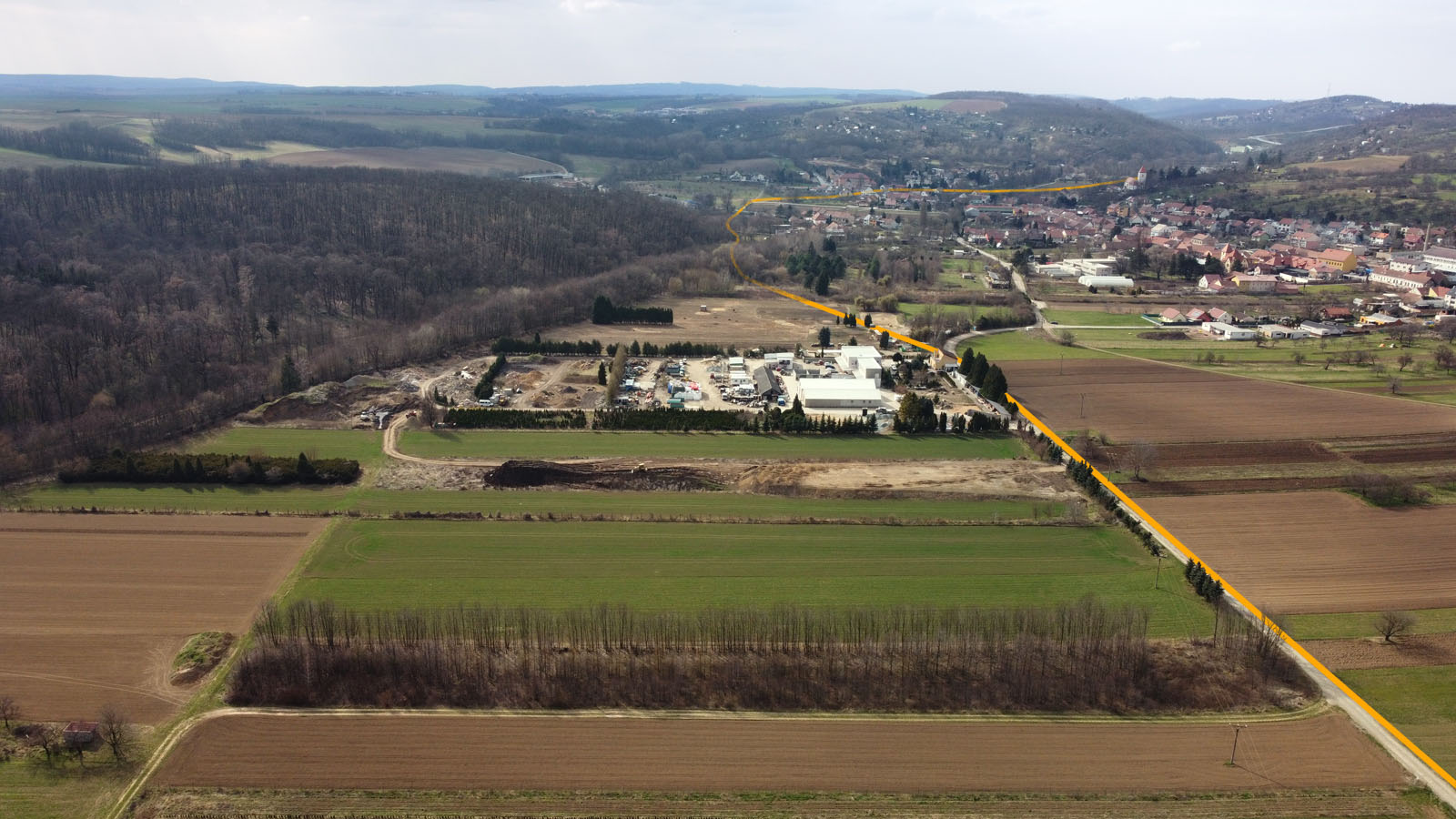 Pohled k západu na „železniční obchvat Želešic“. Za zahradnictvím zahnula úzkorozchodka k jihozápadu na most přes Obravu neboli Bobravu.