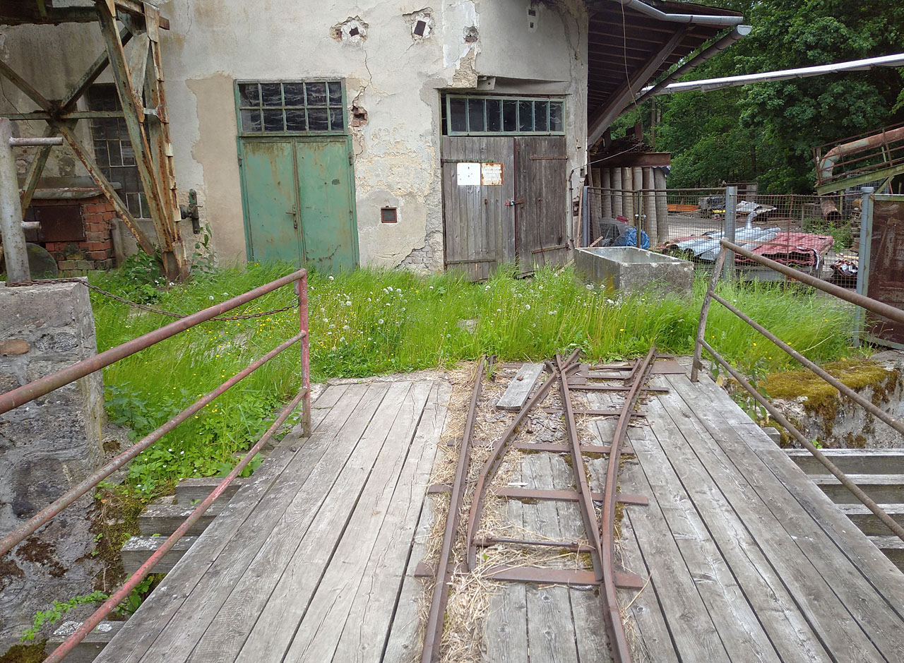 Romantická výhybka na konci mostu umožňovala buď objet budovu katru zprava podél zkoseného nároží nebo vraty v něm projet přímo dovnitř.