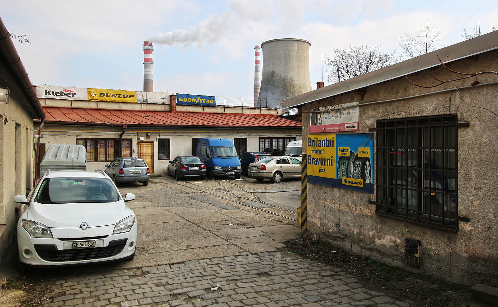 Z ulice nevypadá pohled do dvora s autoservisem nijak nápadně. Teprve při bližším průzkumu narazí oko pátrače na koleje po desetiletí zalité v betonu dvora.