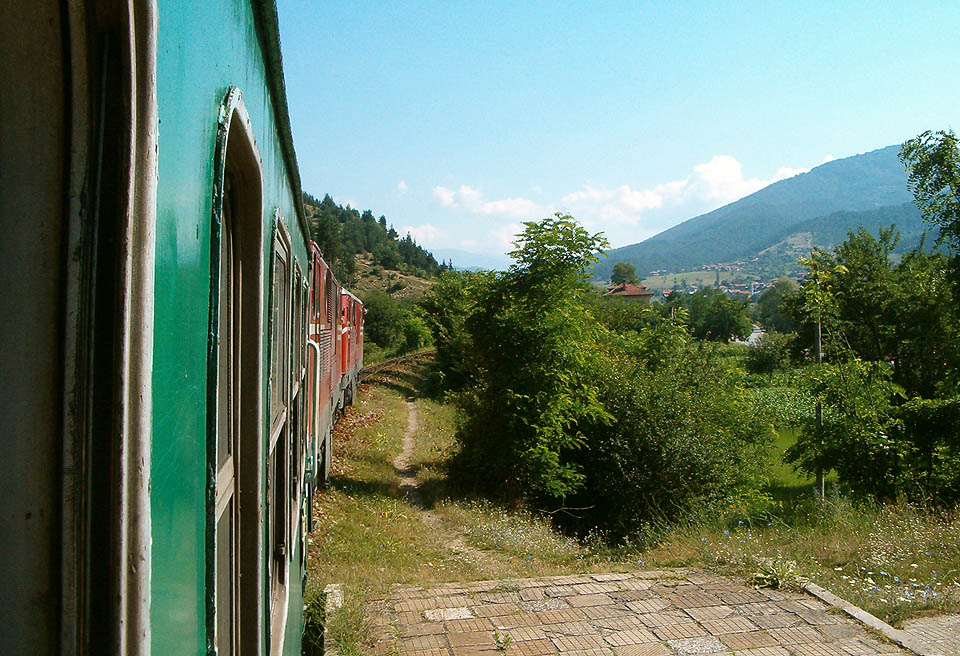 Osobní vlak vedený dvěma lokomotivami řady 77 na pláni před stanicí Черна Места.