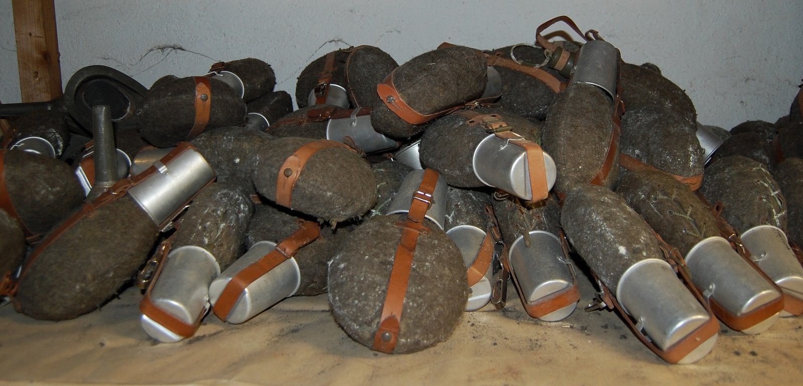 Hromada polních lahví s elegantními hliníkovými kalíšky na pití měla posloužit až 300 ukrývaným osobám.