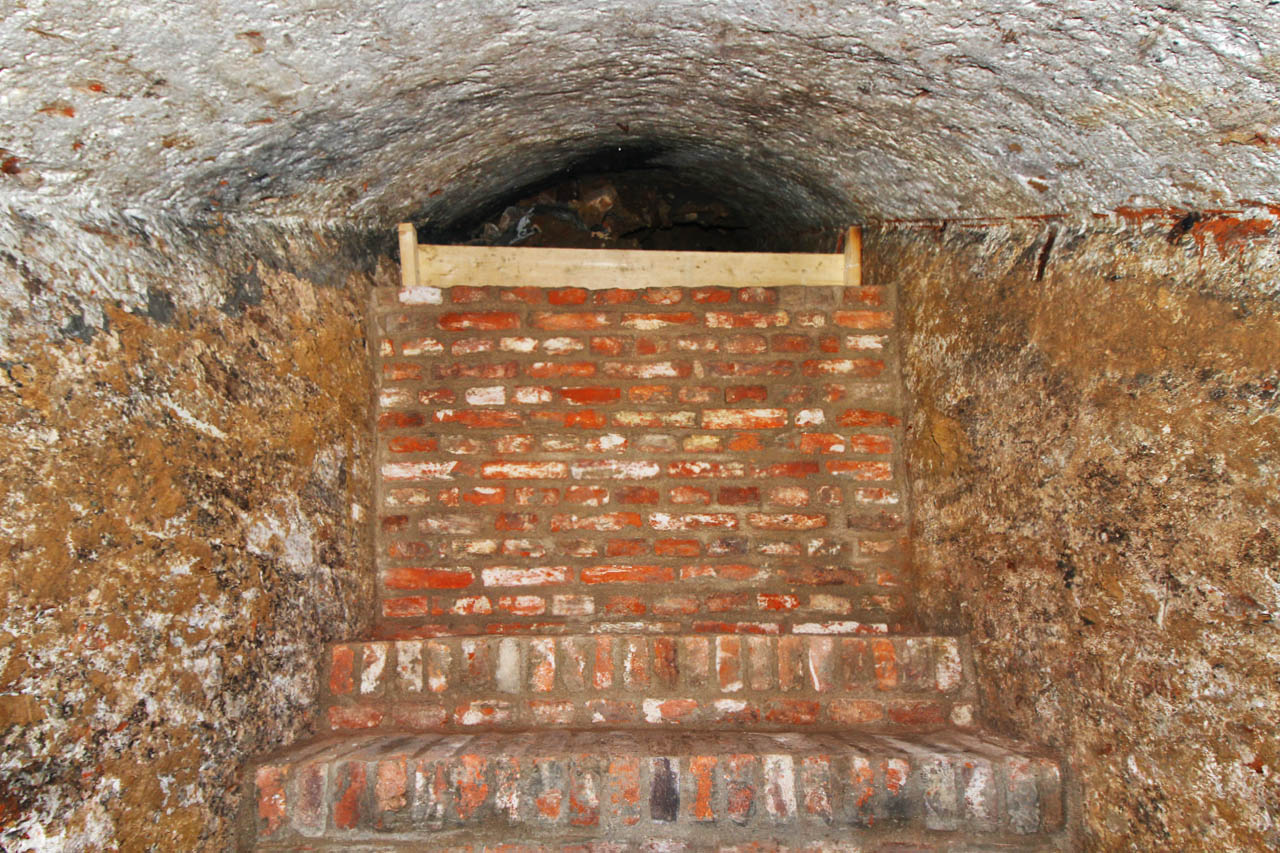 Schodiště pokračuje dál, jeho prostor je však zasypán odpadem a sutí, která původně vyplňovala celý prostor rozsáhlého sklepa.