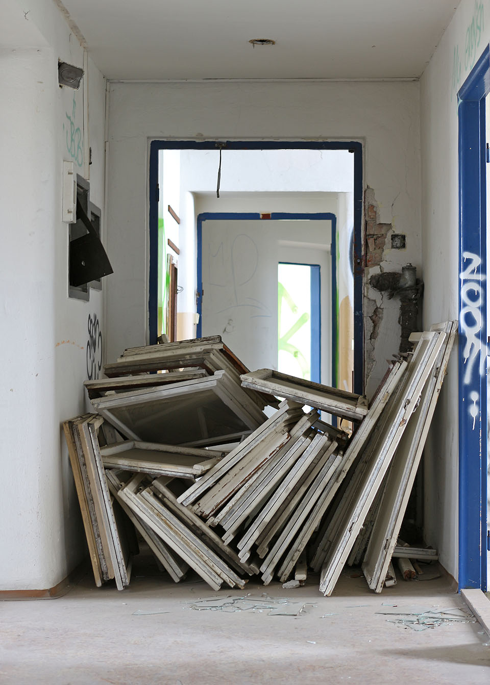 Nepečlivě naskládané okna v chodbě měla zřejmě zamezit zvědavcům v proniknutí do vzdálenější části domu. Podezříváme z tohoto úmyslu místní bezdomovce.