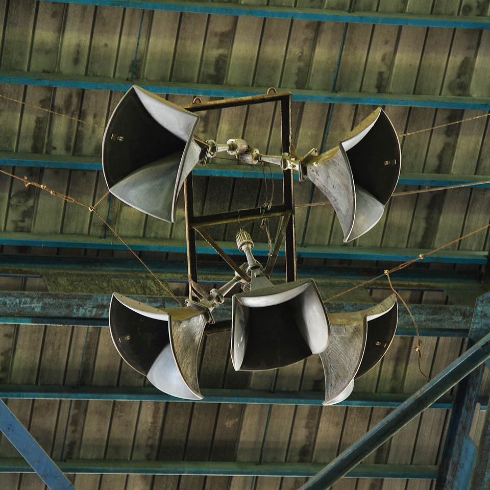 Také oněmělé tlampače u stropu čekají na příležitost, aby zaplavily dnes prázdný stadion řevem sportovního utkání.