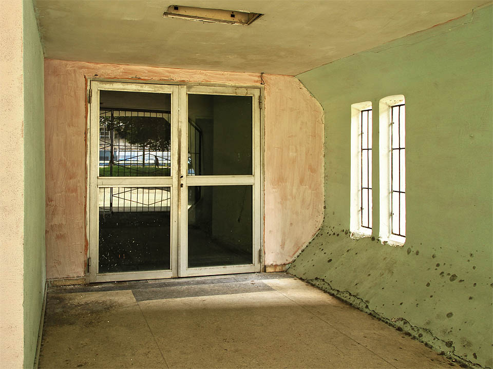 Rozmáchlé široké vchody do stadionu v kosmickém stylu později nahradily uměřené hliníkové dveře.