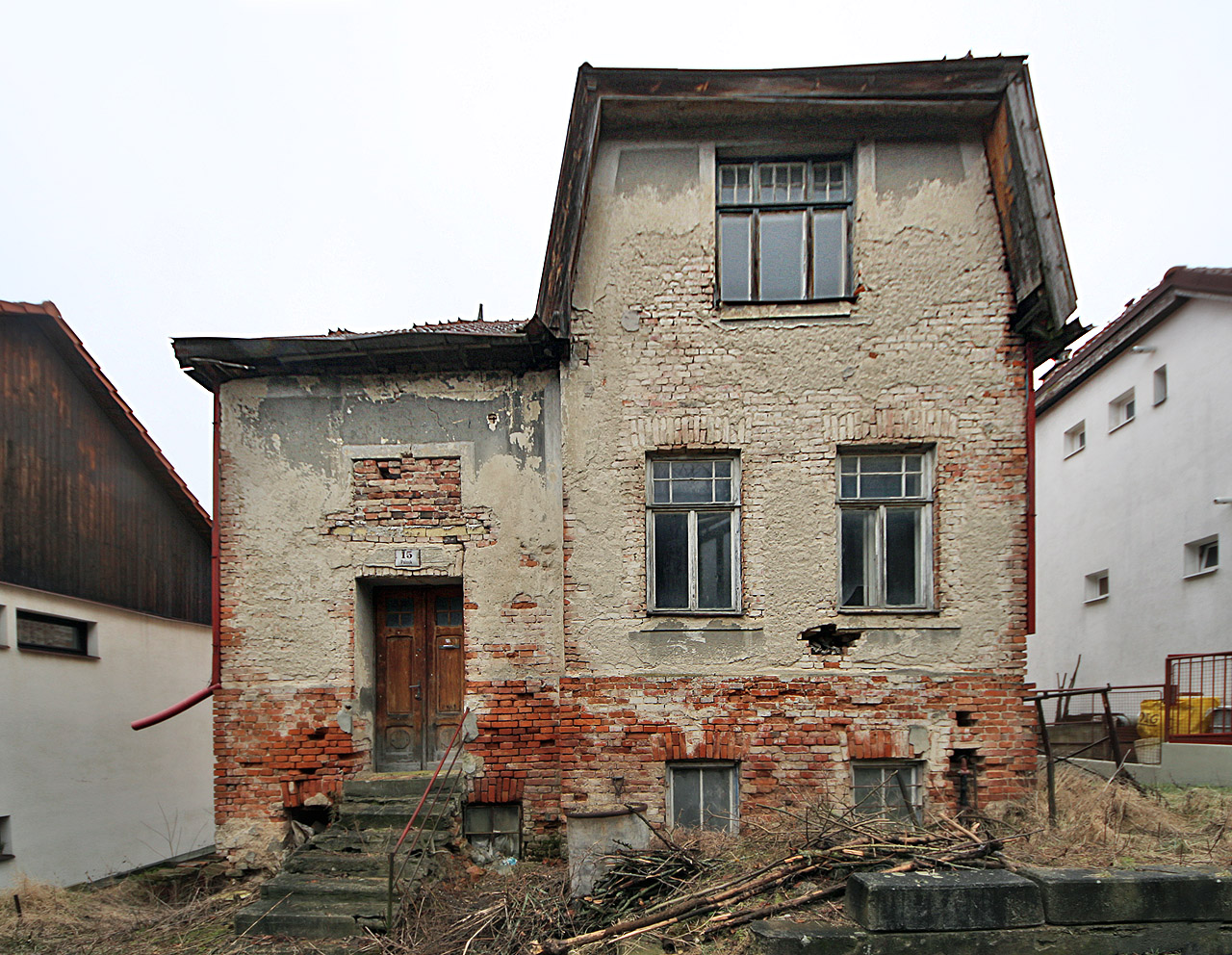 Horní, zřejmě hlavní vstup do domu, ze slepého appendixu ulice Kamínky. Ulička Palouk nebyla původně slepá jako dnes a z jejího horního konce bylo možné projít jak na jih na ulici Kamínky, tak na sever, do místa, kde se potkávají tři větve Raisovy ulice.