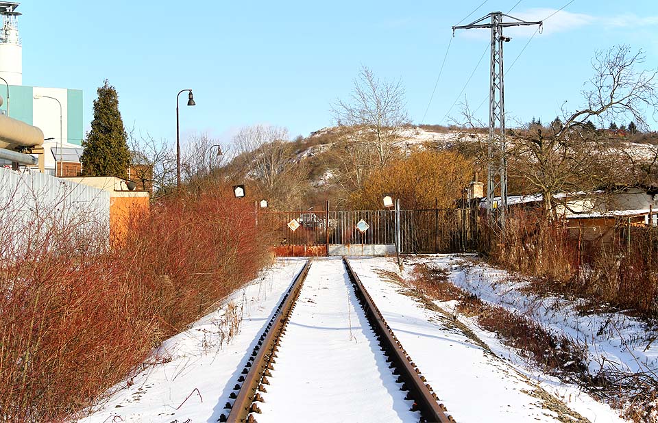 Za plechovými vraty vlečka pokračuje přímě ve směru k temeni Stránské skály.