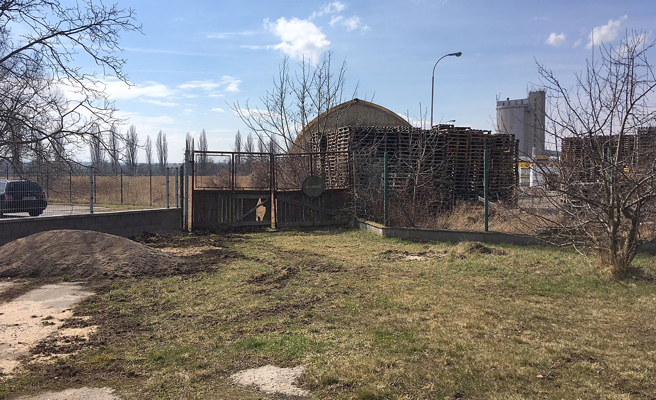 Pohled na bránu, kterou vlečka opouštěla areál českobrodského cukrovaru a pokračovala přejezdem přes Cukrovarskou ulici do areálu liblického cukrovaru.