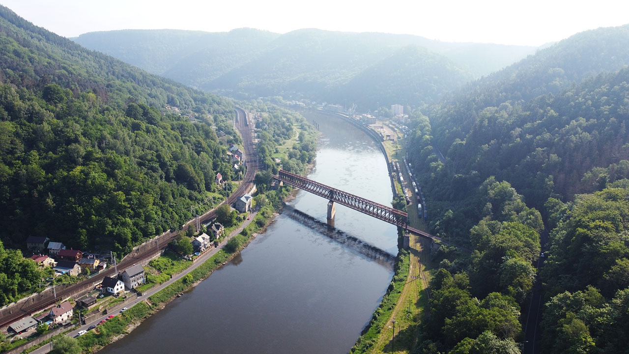 Na snímku z června 2021 lze v jarním oparu spatřit kromě mostu přes Labe z roku 1874 (s mostovkou z roku 1916)na pravém břehu řady stojících nákladních vozů na kolejích přístavní vlečky. Po břehu labe se koleje vlečky táhnou v délce přes 2 km. 