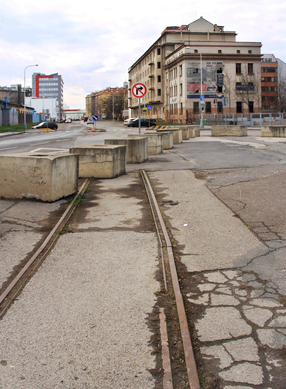Výmluvné torzo koleje na křižovatce ulic Jankovcovy (rovně) a Varhulíkové (doprava). Vpravo od autobusové zastávky odbočovala vlečka do Čistící stanice osiv.