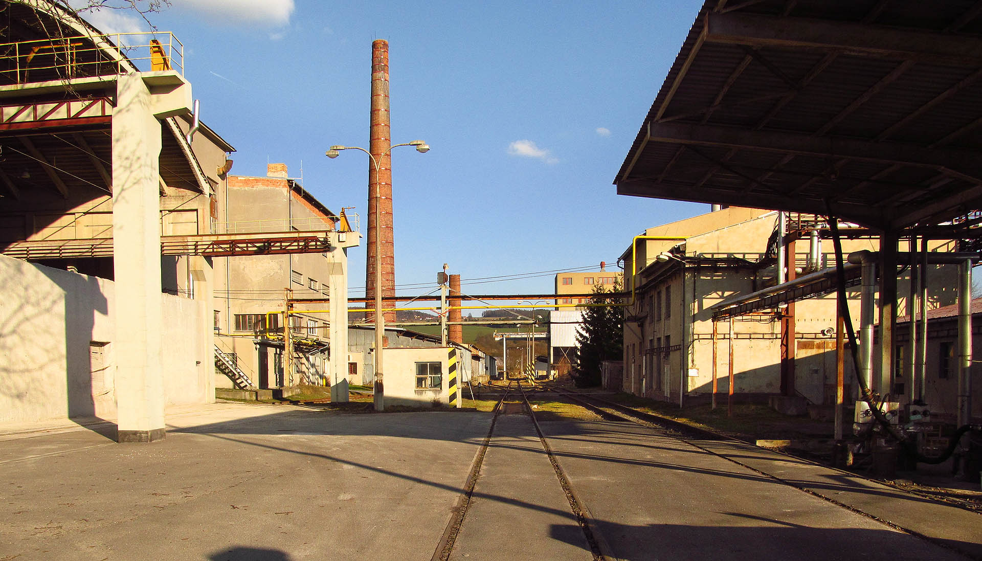 Uvnitř závodu ústí kolej vlečky doprostřed trojkolejného kolejiště. V pravé části snímku je vidět jižní kolej, severní kolej se přimyká k betonové zdi vlevo.
