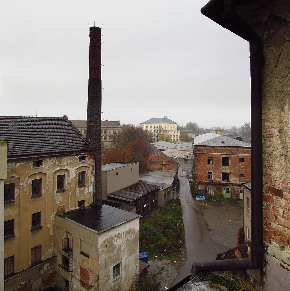 Pohled na Vlněnu z jednoho z mnoha střešních zákoutí. Tady plyne čas jiným tempem a ruch ulic zdola sem doléhá jen napůl. Pohled na Vlněnu z jednoho z mnoha střešních zákoutí. Tady plyne čas jiným tempem a ruch ulic zdola sem doléhá jen napůl.
