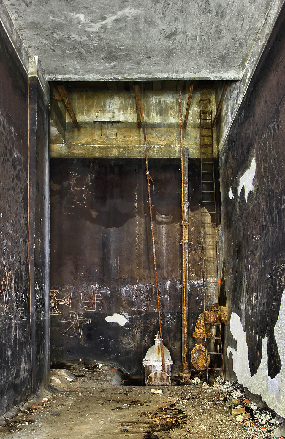 Detailní pohled na vstupní šachtu nového vodojemu s šoupětem a armaturou vedoucí do šoupátkové komory. Výzdoba na stěnách je výmluvná. Detailní pohled na vstupní šachtu nového vodojemu s šoupětem a armaturou vedoucí do šoupátkové komory. Výzdoba na stěnách je výmluvná.