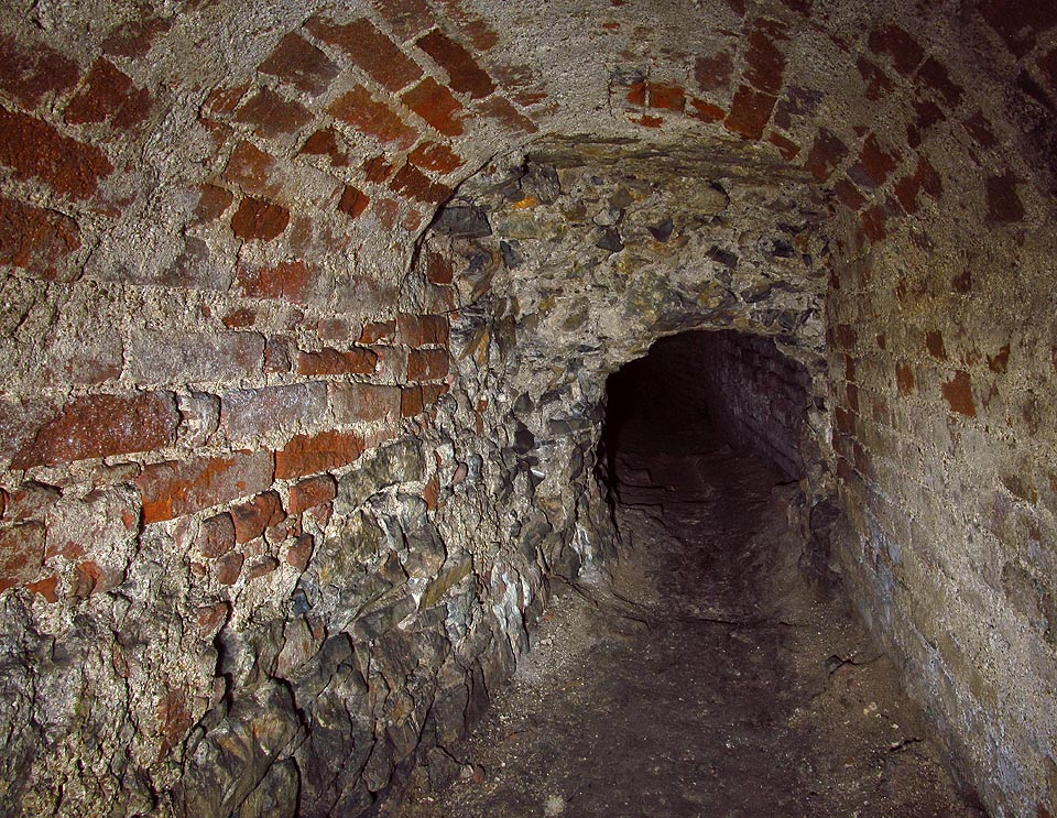 Posléze začne chodba strmě klesat. Logicky již v tomto úseku tedy nemůže jít o vodovodní přivaděč, ale pouze odpadní stoku. Zde prochází pod bývalou vnější hradbou kláštera (klášter měl vlastní opevnění sousedící s městskými hradbami).