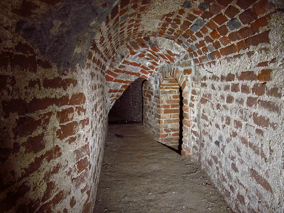 Zde již vstupujeme (obloukem vpravo) do skutečné vodovodní a kanalizační štoly. Užší a nižší.