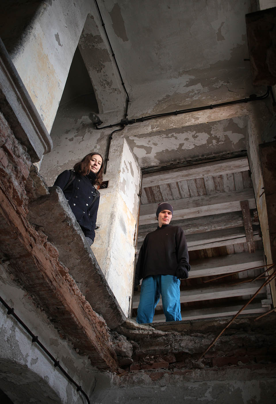 Profesionální pohled kolegů z bezpečí pevné části konstrukce na prolomené schodiště.