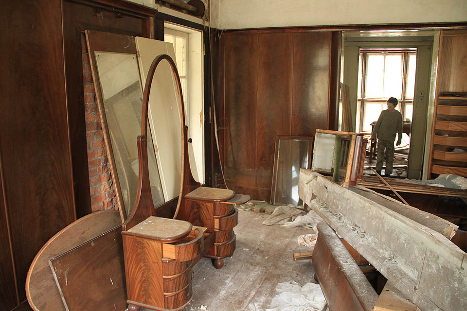 Na zbytky luxusního nábytku ve dřevem obložených pokojích usedá prach. V jeho vrstvě je občas vidět stopy malých zvířat.