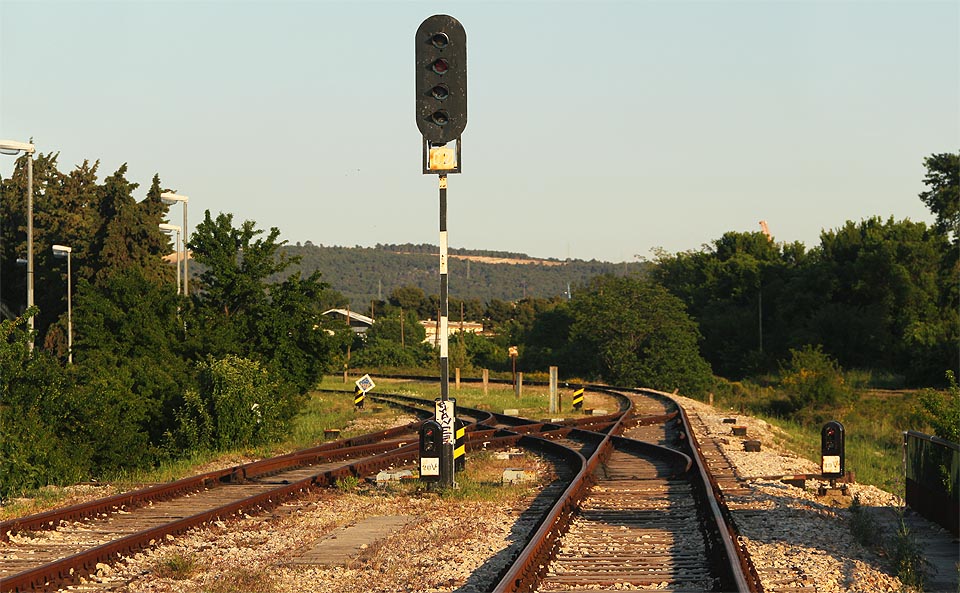 Jižní (a jediné) zhlaví osobní části stanice. Vlevo odbočuje (a dále se větví) manipulační kolej, vpravo za trpasličím návěstidlem je vidět konec vlečkového kolejiště přístavu.
