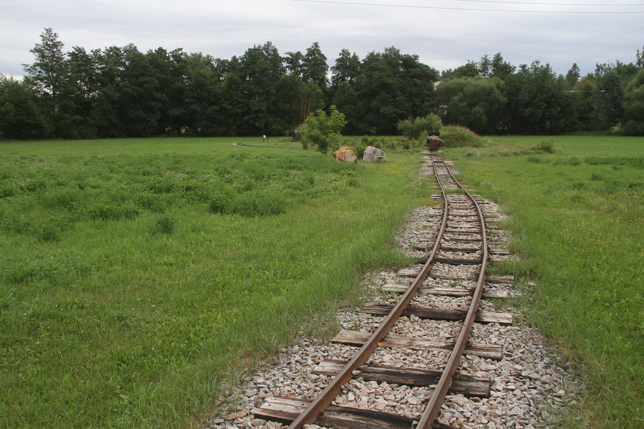Pohled na druhou stranu k jezírku, na kusou kolej s odstavenými nákladními vozy a jezírko, kterému by slušela kolejová smyčka (ale není tam, jen výhybna pro objíždění soupravy).