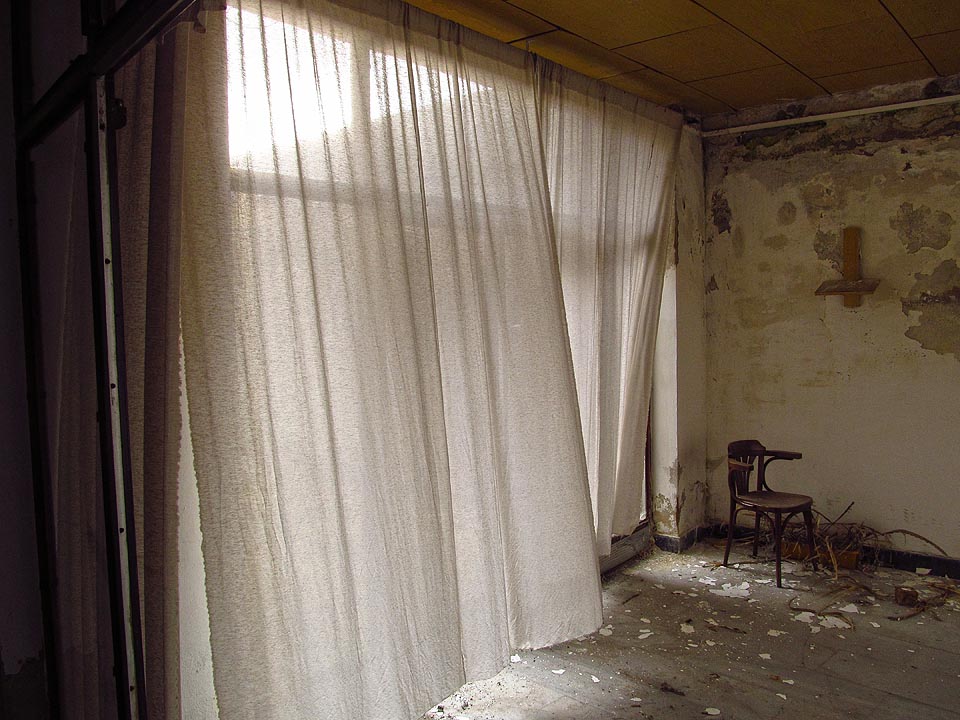 Záclony povlávající ve větru působí poněkud strašidelně. Podobně jako v OP Prostějov, které již také odnesl čas.