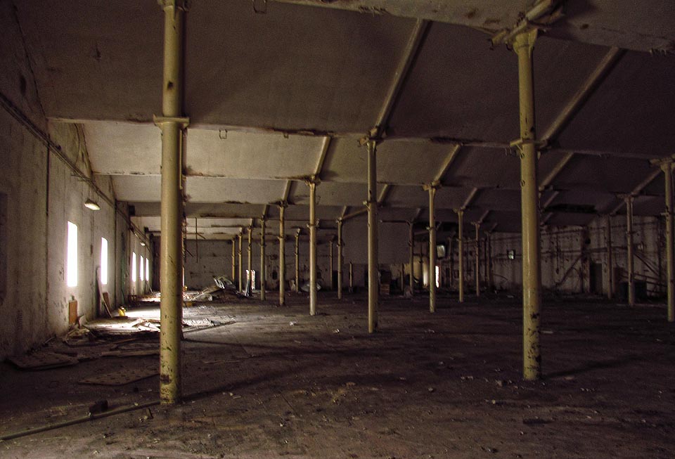 Nejstarší část tkalcovny. Poněklud potemnělá výrobní hala s litinovými sloupy nesoucími typicky pilovitě zaloměnou konstrukci střechy. Tady je cítit kus umírající historie.