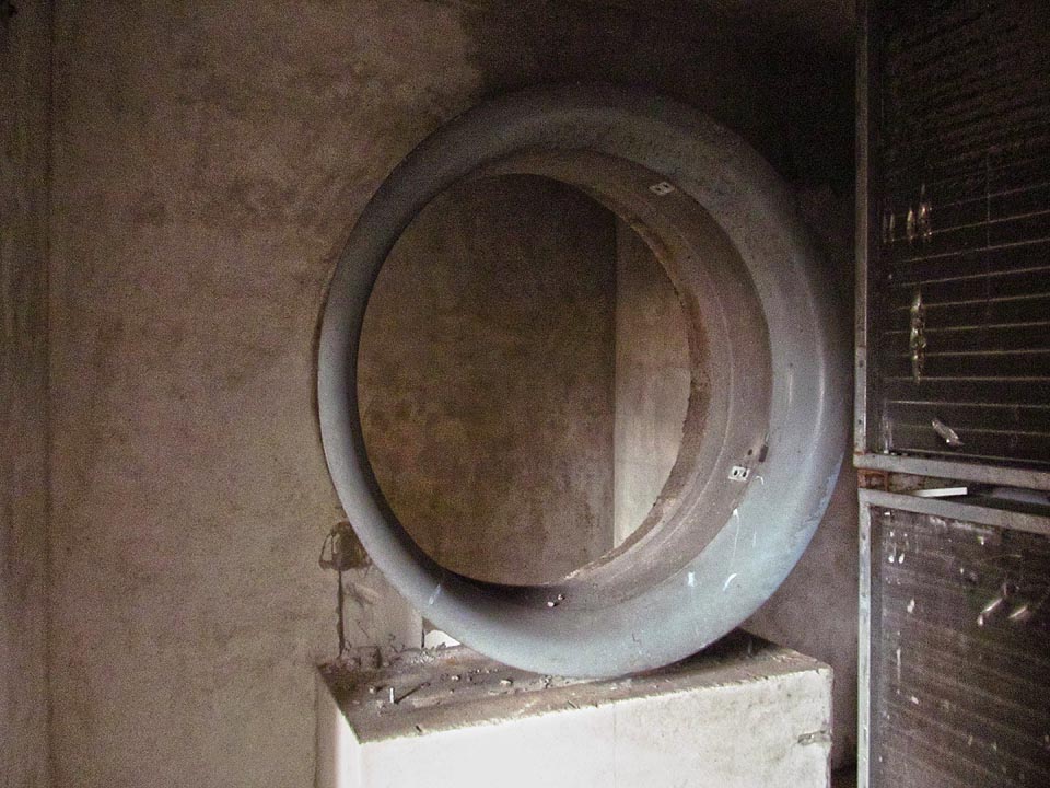 V zadní části továrny čeká nejpodivnější objev. Příruba záhadného válcového stroje, který procházel přes několik místností. Snad součást vzduchotechniky s rotačními filtry?