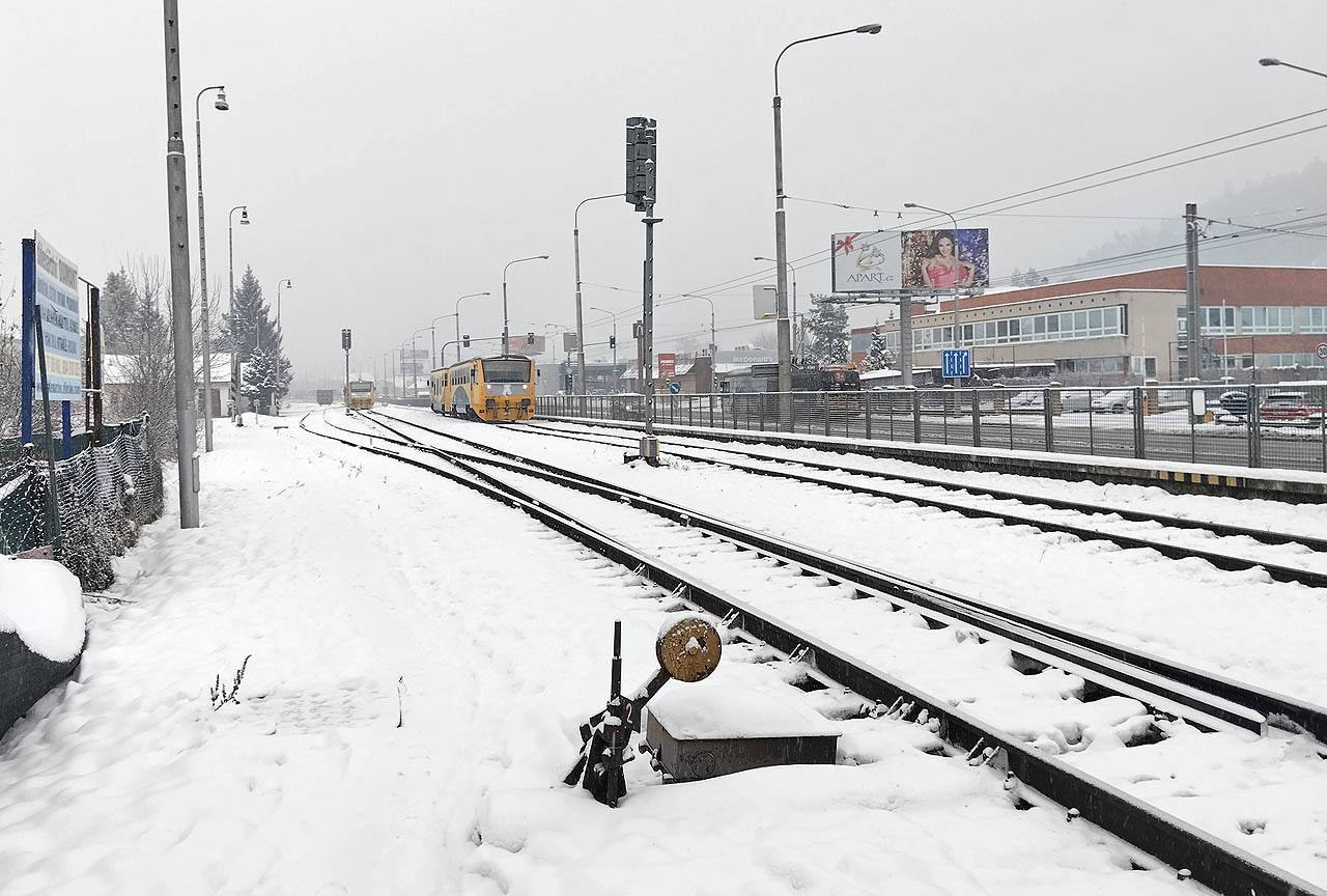 Osobní vlak 14253 z Kroměříže do Zlína středu se ve Zlíně-Malenovicích právě míjí s čekajícím osobním vlakem č. 14254 v opačné relaci. Půl minuty před devátou hodinou ranní na Mikuláše v roce 2023.